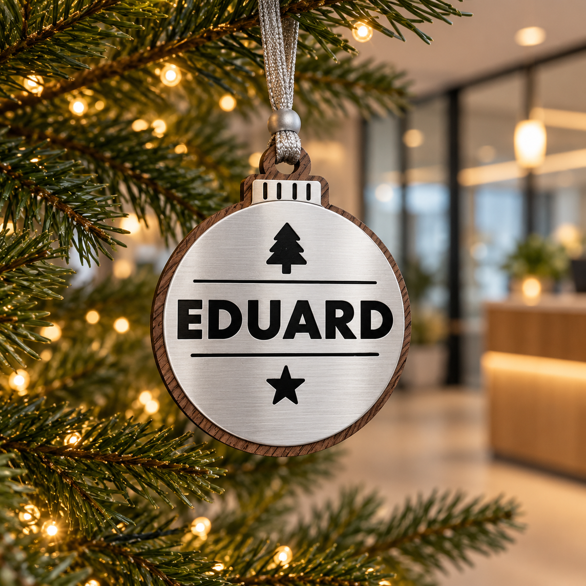 Silver personalised Christmas bauble Design 2, lifestyle photograph; decorative props not included. Hanging strip colour varies.