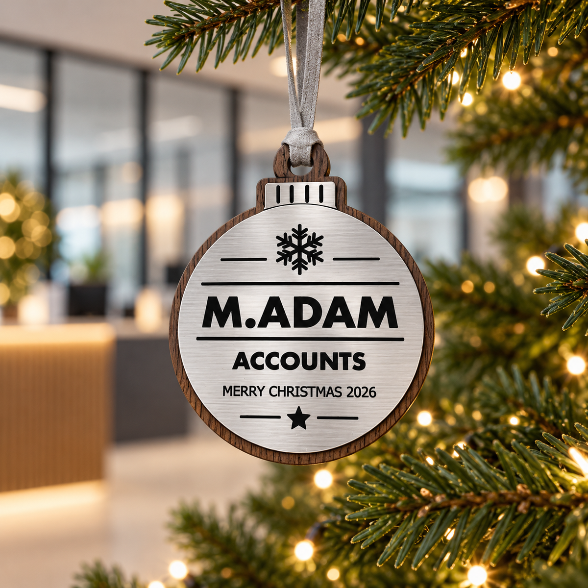 Silver personalised Christmas bauble Design 3, lifestyle photograph; decorative props not included. Hanging strip colour varies.